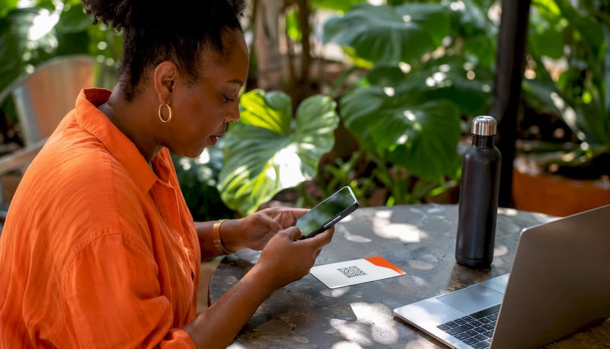 Hands scanning eSIM QR code in coworking space