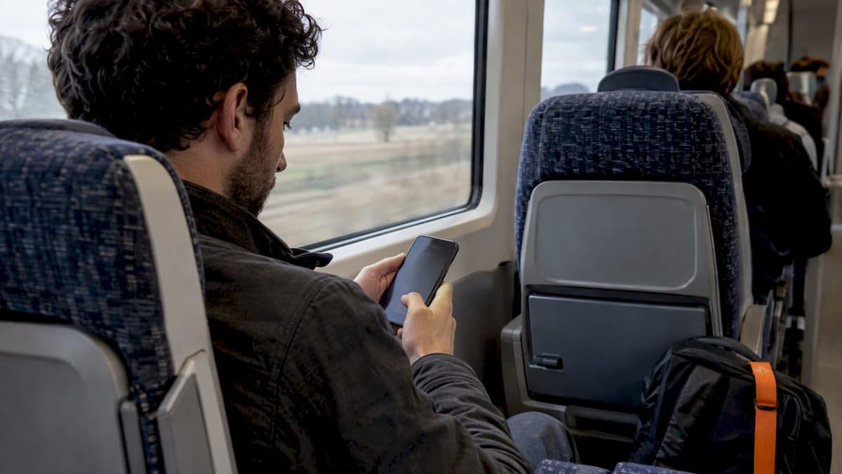 Traveler reviewing eSIM plan terms on train
