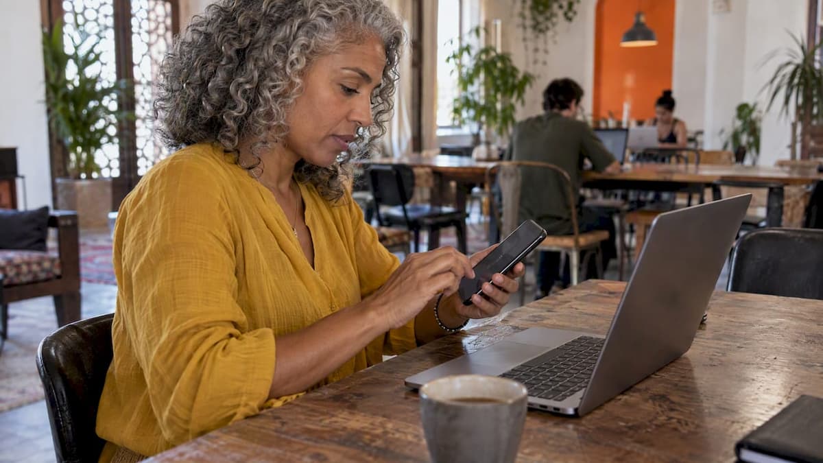 Traveler setting up phone hotspot beside laptop